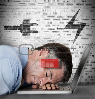 Businessman sleeping on his laptop with low energy and charging symbols