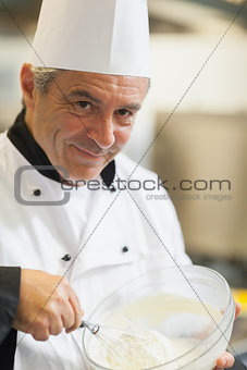 Smiling chef whisking cream