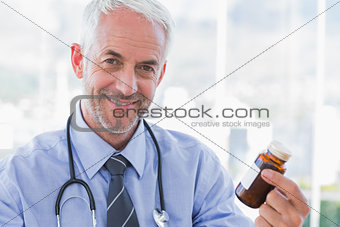 Smiling doctor holding medicine jar