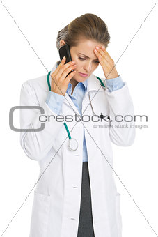 Concerned doctor woman talking mobile phone