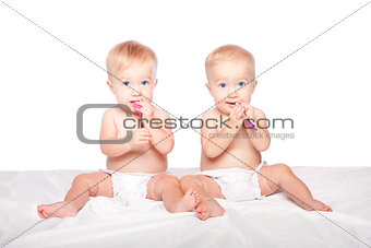 Cute twins babies with spoons