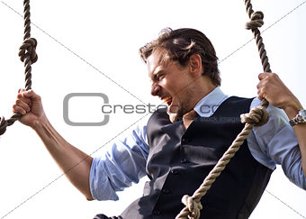 Strong, able businessman climbing ropes