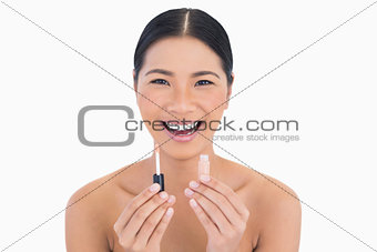 Cheerful beautiful model holding lip gloss
