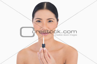 Peaceful attractive model holding lip gloss