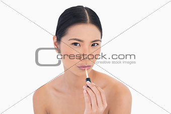 Sensual young model applying lip gloss