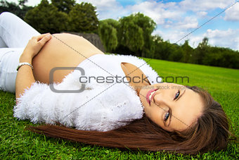 Pregnant woman lying on the grass
