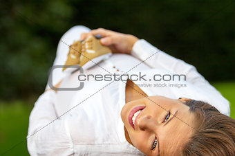 Portrait pregnant woman lying on the grass