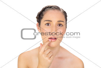 Natural model pointing at her bottom lip