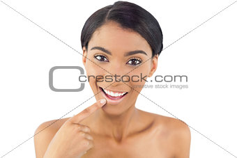 Smiling woman pointing at her lip