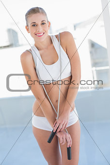 Charming young blonde model posing with a skipping rope