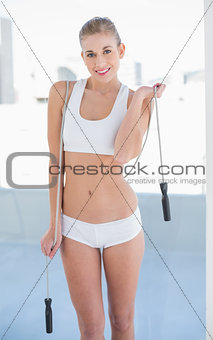 Cheerful young blonde model playing with a skipping rope