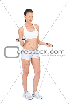 Fit woman in sportswear exercising with skipping rope
