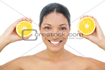 Smiling black haired model holding orange slices