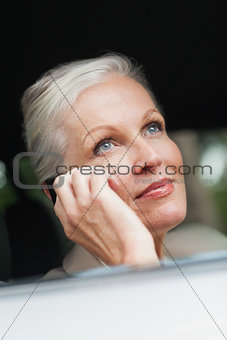 Businesswoman on the phone driving classy car