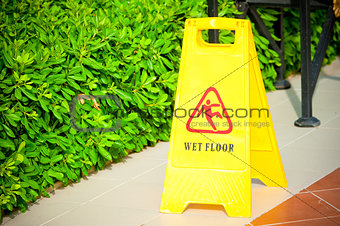warning label "Wet floor" yellow on the tile floor