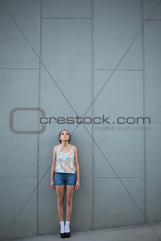 Attractive woman standing in front of a grey wall