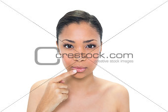 Peaceful young dark haired model touching her lip