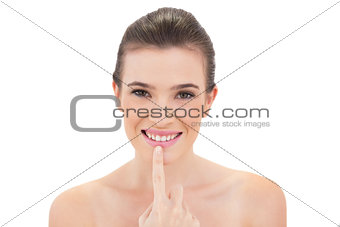 Cheerful natural brown haired model touching her lip