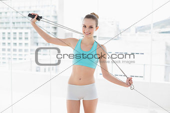 Sporty smiling woman holding skipping rope