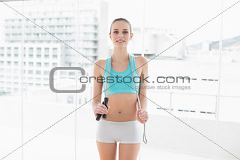Sporty content woman holding skipping rope