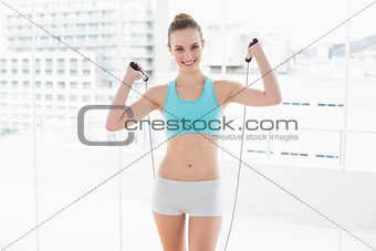 Sporty content woman exercising with skipping rope