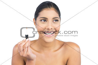 Cheerful nude brunette holding lip gloss