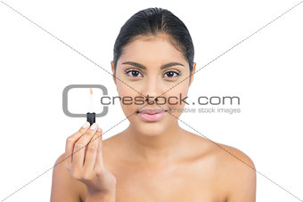 Pleased nude brunette holding lip gloss