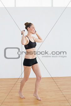 Side view of content sporty woman holding a skipping rope