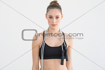 Attractive sporty woman posing holding a skipping rope