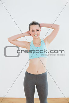 Smiling fit woman standing in fitness studio