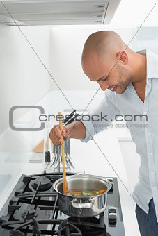 Side view of smiling man preparing food in kitchen