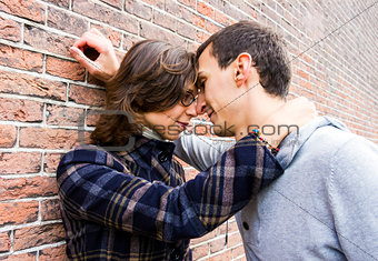 Portrait of love couple outdoor looking happy against wall backg