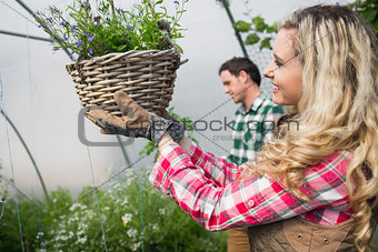 Beautiful woman touching a hanging flower basket