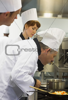 Male mature chef tasting some food