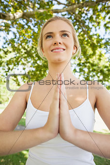 Front view of young woman meditating in sukhasana pose