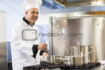 Smiling head chef stirring in pot