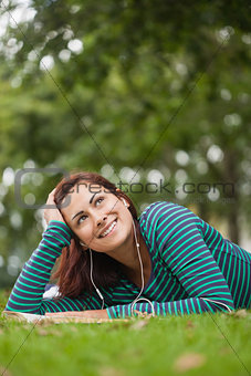 Day dreaming casual student lying on grass looking up