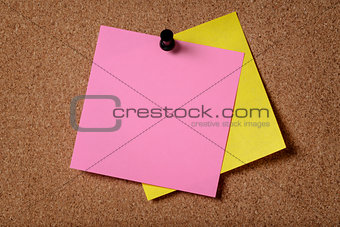 two reminders sticky note on cork board