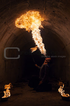 Young man blowing fire from his mouth