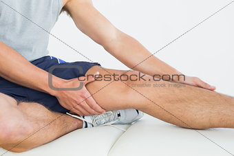 Man with his hands on a painful leg