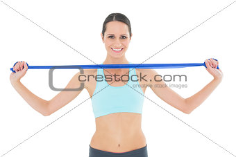 Smiling fit young woman holding blue yoga belt