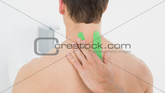 Physiotherapist putting on green kinesio tape on patients back
