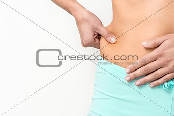 Woman checking her waist for excess weight