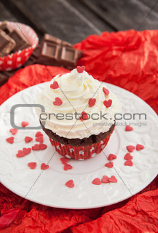 Chocolate cupcake decorated with red hearts