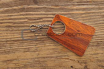 Label with chain on wooden background