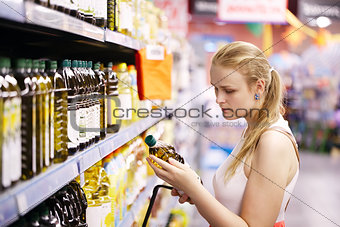 Young woman buying olive oil
