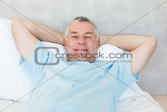 Senior man lying in bed