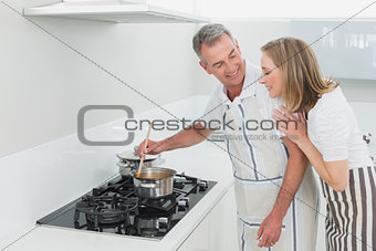Side view of a couple preparing food in kitchen