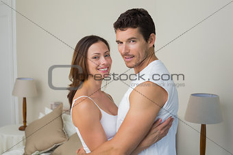 Happy couple with arms around at home
