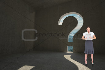 Composite image of shocked stylish businesswoman holding newspaper